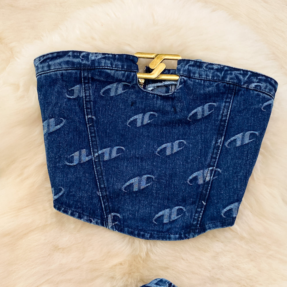 Blue denim bag with gold clasp on a light beige background