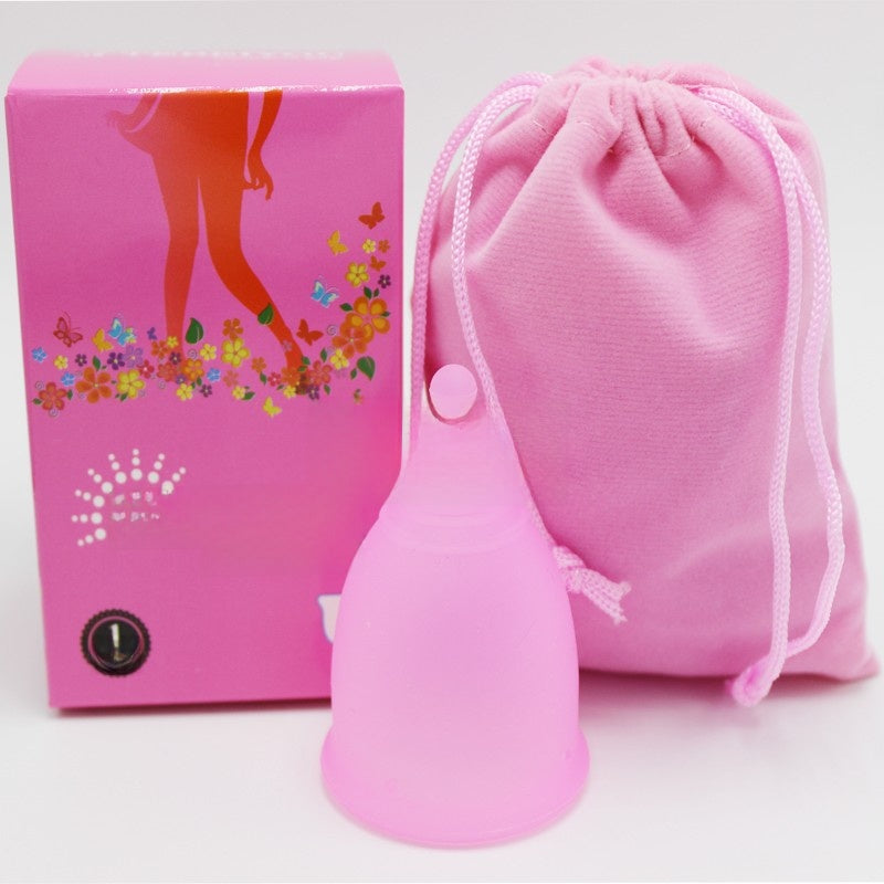 Pink silicone product with packaging and drawstring bag on a white background