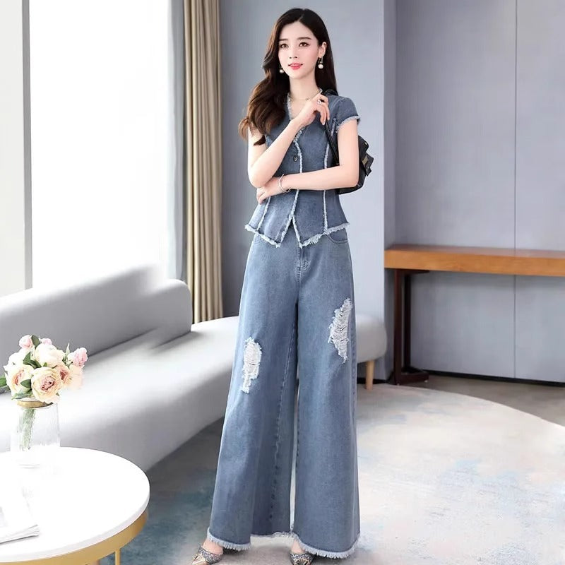 Woman in a denim outfit standing in a modern living room.