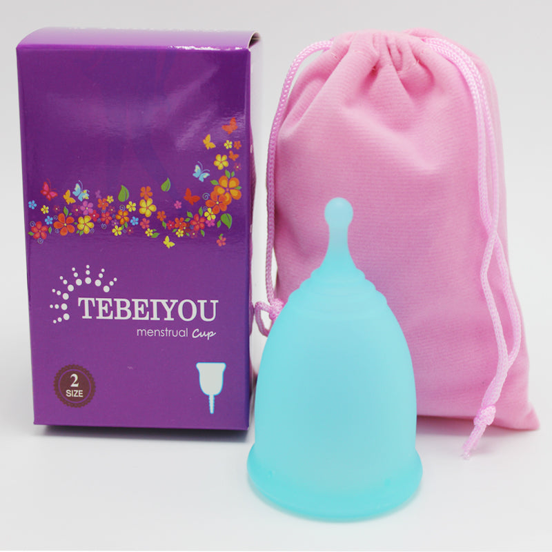 Menstrual cup with packaging and pink drawstring bag on a white background